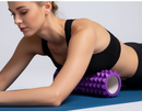 Mulher usando rolo de massagem roxo